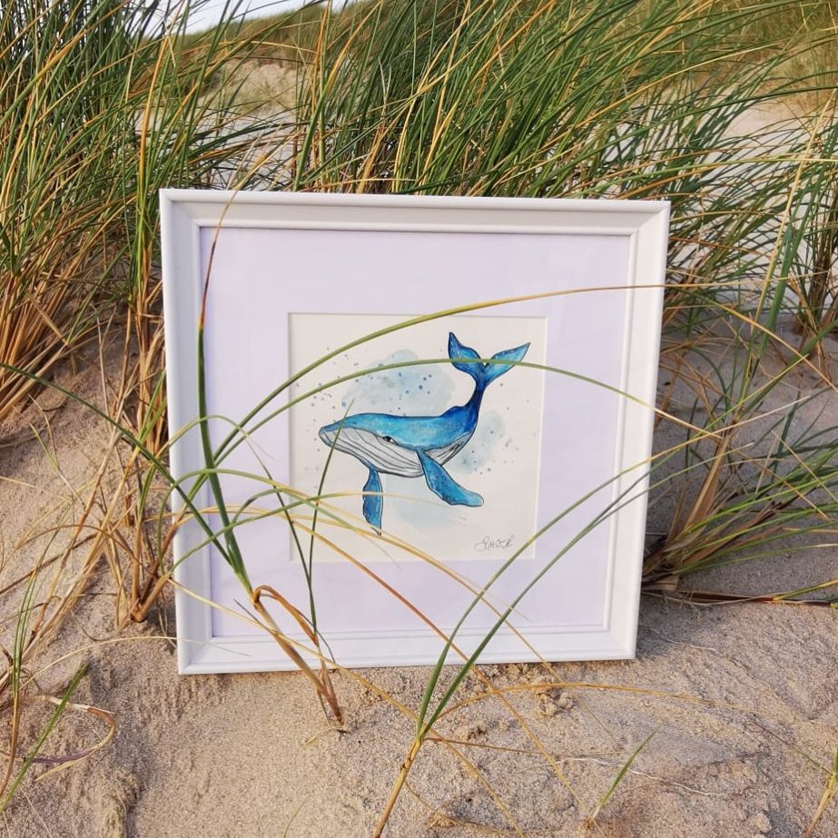 Wal by Aquarella Rahmen mit Aquarell eines Wals, umgeben von Gras im Sand.